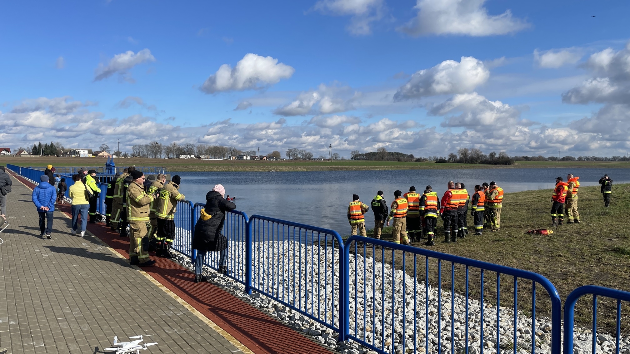 manewry na zalewie, na brzegu zbiornika strażacy, na widokowej części zapory stoją mieszkańcy obserwujący ćwiczenia