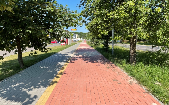 Chodnik wraz z ścieżką rowerową na ul Poznańskiej - widok na wykonaną ścieżkę w centrum miejscowości po obu stronach pas zieleni z drzewami