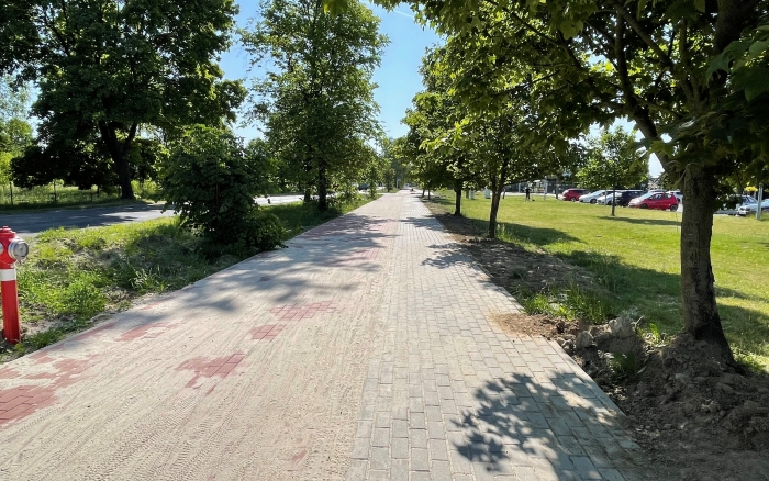 Chodnik wraz z ścieżką rowerową w Tulcach - widok na wykonaną ścieżkę w centrum miejscowości po obu stronach pas zieleni z drzewami